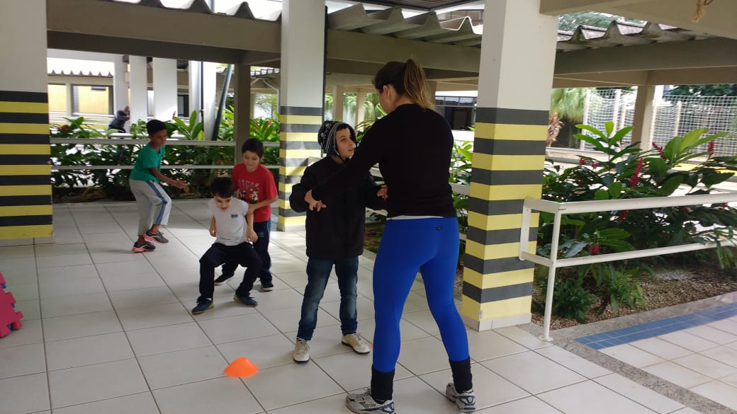 Na foto em frente a academia professora Luiza com os alunos (Arthur, Gabriel, Samuel e Lucas) da escolinha de atletismo, praticando aquecimento para iniciar as atividades.
